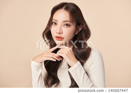 A beautiful young Asian woman with clean, fresh skin against a beige background. Skincare, facial treatment, cosmetology, beauty, and spa. An elegant portrait of an Asian woman. A beautiful young Asian woman with clean, fresh skin against a beige background. Skincare, facial treatment, cosmetology, beauty, and spa. An elegant portrait of an Asian woman. 140887447