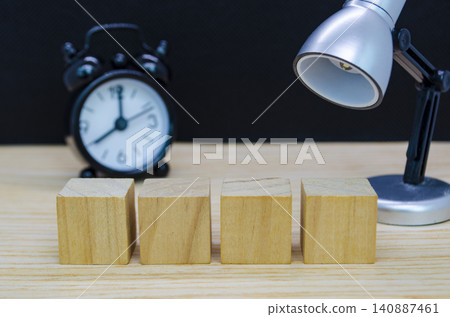 Rustic wooden cube display with alarm clock against a dark backdrop for premium product presentation concepts. Rustic wooden cube display with alarm clock against a dark backdrop for premium product presentation concepts. 140887461