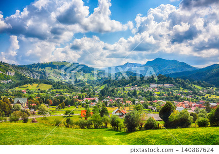 Amazing alpine landscape with green fields and Piatra Craiului mountains in Dambovicioara Commune. Amazing alpine landscape with green fields and Piatra Craiului mountains in Dambovicioara Commune. 140887624
