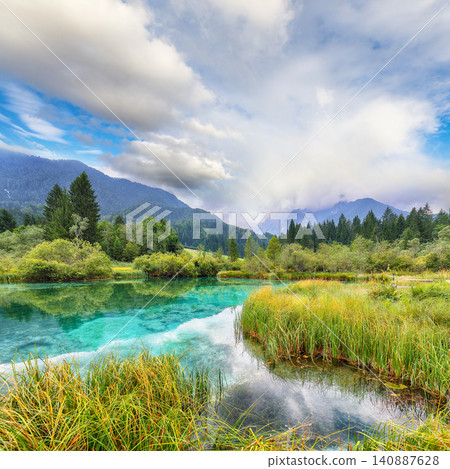 Gorgeous summer view on Zelenci lake with beautiful reflections in water. Gorgeous summer view on Zelenci lake with beautiful reflections in water. 140887628