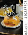 Fruit tea with mango and mint in a glass teapot on the table 140887708