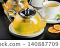 Fruit tea with mango and mint in a glass teapot on the table 140887709