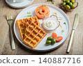 Crunchy waffle fries with sour cream dip served in a basket 140887716