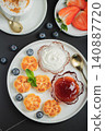 Cottage cheese pancakes, syrniki, curd fritters decorated with strawberry and raspberry served on a white plate. Homemade breakfast concept 140887720