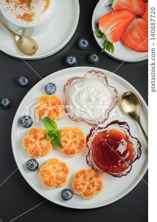 Cottage cheese pancakes, syrniki, curd fritters decorated with strawberry and raspberry served on a white plate. Homemade breakfast concept Cottage cheese pancakes, syrniki, curd fritters decorated with strawberry and raspberry served on a white plate. Homemade breakfast concept 140887720