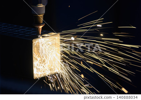 High-precision fiber laser machine cutting and engraving a metal square tube with sparkling light. 140888034