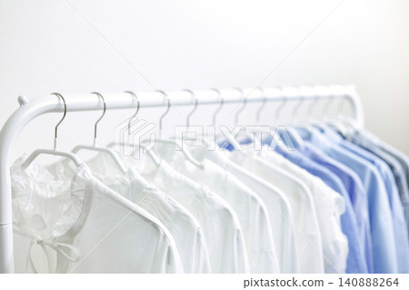 A hanger rack filled with tops in refreshing white and blue colors. A hanger rack filled with tops in refreshing white and blue colors. 140888264