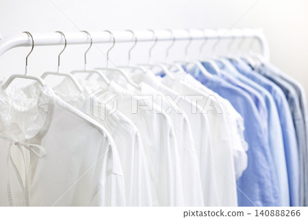 A hanger rack filled with tops in refreshing white and blue colors. A hanger rack filled with tops in refreshing white and blue colors. 140888266
