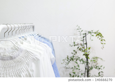 A hanger rack filled with tops in refreshing white and blue colors. 140888270