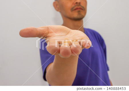 Asian man showing palm with rough skin callus. Close up of hand with hardened skin caused by heavy manual labor. Concept of physical activity, hard work, construction and sports exercise. Asian man showing palm with rough skin callus. Close up of hand with hardened skin caused by heavy manual labor. Concept of physical activity, hard work, construction and sports exercise. 140888453