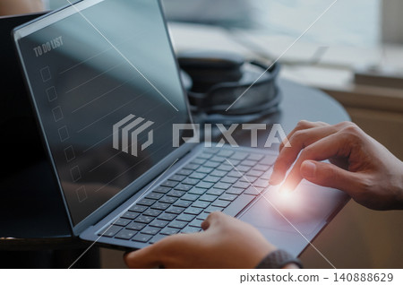 A man's hands as he checks and operates a to-do list on his laptop. A man's hands as he checks and operates a to-do list on his laptop. 140888629