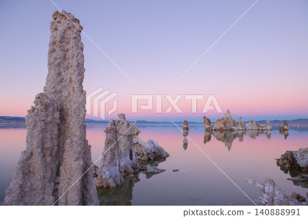 Sierra nevada california tufa lake sunrise pastel sky calm water reflection at dawn with mineral tower and serene desert shore 140888991