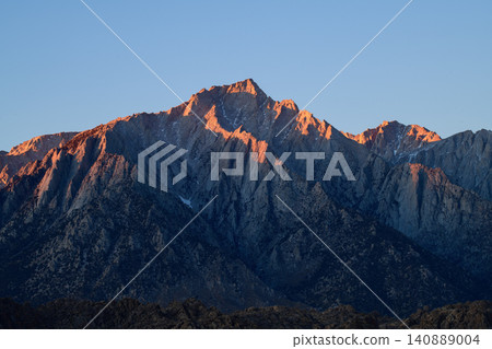 Sierra nevada california mountain sunrise alpine peak rugged granite ridge glow under clear blue sky with dramatic wilderness landscape Sierra nevada california mountain sunrise alpine peak rugged granite ridge glow under clear blue sky with dramatic wilderness landscape 140889004