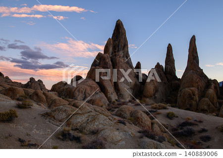 Sierra nevada california rock spire desert landscape under soft sunset sky with rugged granite formation and quiet wilderness terrain Sierra nevada california rock spire desert landscape under soft sunset sky with rugged granite formation and quiet wilderness terrain 140889006