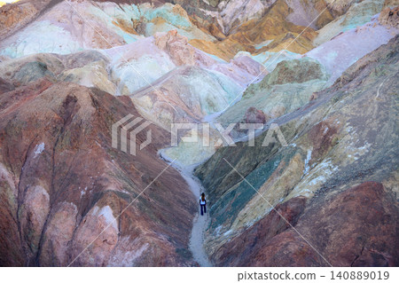 Sierra nevada california colorful canyon mineral hill with lone hiker on desert trail across rugged geology under soft natural light Sierra nevada california colorful canyon mineral hill with lone hiker on desert trail across rugged geology under soft natural light 140889019