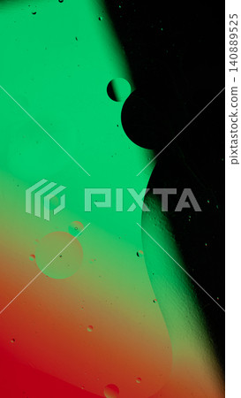 Abstract liquid surface showing oil drops creating a colorful pattern of green and red Abstract liquid surface showing oil drops creating a colorful pattern of green and red 140889525
