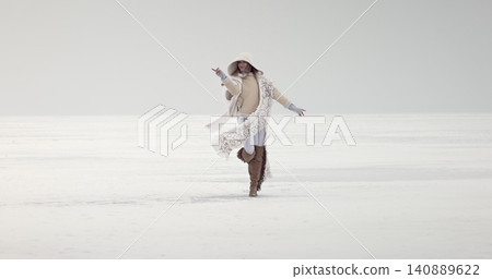 Woman dancing freely on white snowy landscape Woman dancing freely on white snowy landscape 140889622