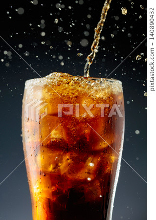 Sparkling cola is poured into a misted glass with ice. Sparkling cola is poured into a misted glass with ice. 140890432