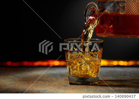 Whiskey is poured into a crystal glass. Whiskey is poured into a crystal glass. 140890437