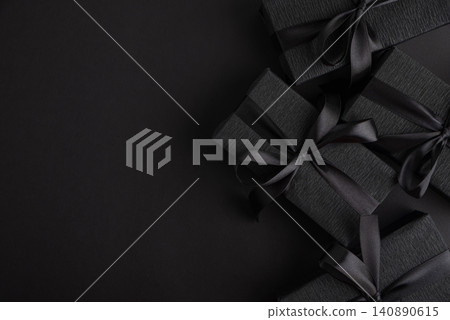 Black gift boxes with ribbon on dark background Black gift boxes with ribbon on dark background 140890615