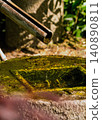 A drop of water falling into a tsukubai (a squat basin in a Japanese garden). 140890811