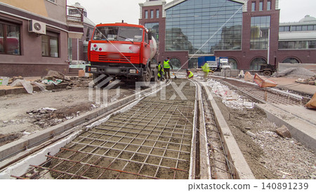 Pouring ready-mixed concrete after placing steel reinforcement to make the road by concrete mixer timelapse hyperlapse. Pouring ready-mixed concrete after placing steel reinforcement to make the road by concrete mixer timelapse hyperlapse. 140891239