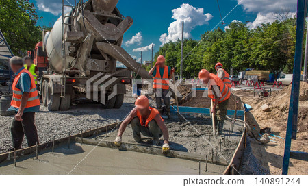 Concrete leveling works for road construction with many workers and mixer timelapse Concrete leveling works for road construction with many workers and mixer timelapse 140891244