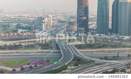 Aerial view of a road intersection in a big city at sunset timelapse. Aerial view of a road intersection in a big city at sunset timelapse. 140891563