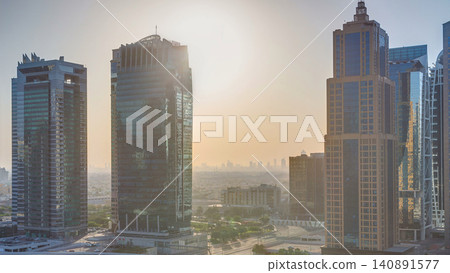 Aerial view of Jumeirah lakes towers skyscrapers at sunrise timelapse with traffic on sheikh zayed road. Aerial view of Jumeirah lakes towers skyscrapers at sunrise timelapse with traffic on sheikh zayed road. 140891577
