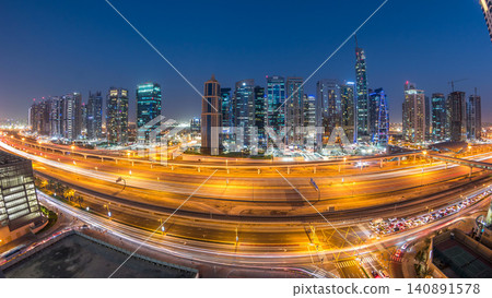 Aerial view of Jumeirah lakes towers skyscrapers day to night timelapse with traffic on sheikh zayed road. Aerial view of Jumeirah lakes towers skyscrapers day to night timelapse with traffic on sheikh zayed road. 140891578