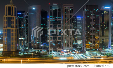 Aerial view of Jumeirah lakes towers skyscrapers during all night timelapse with traffic on sheikh zayed road. Aerial view of Jumeirah lakes towers skyscrapers during all night timelapse with traffic on sheikh zayed road. 140891580