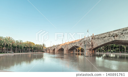 Pont de la Mar bridge timelapse in Valencia, Spain, ornate architecture reflected in a tranquil pond. Pont de la Mar bridge timelapse in Valencia, Spain, ornate architecture reflected in a tranquil pond. 140891761