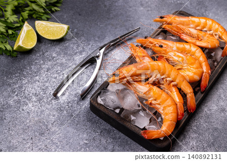 Cooked king prawns on ice with lime and parsley Cooked king prawns on ice with lime and parsley 140892131