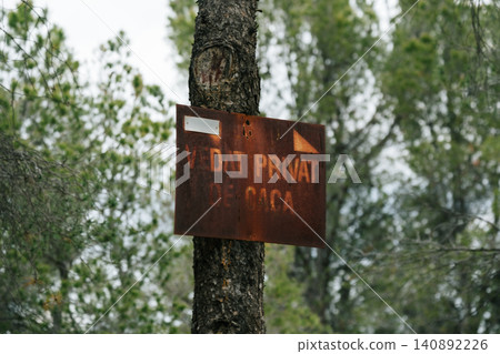 Rustic hunting warning sign on tree in forest environment Rustic hunting warning sign on tree in forest environment 140892226