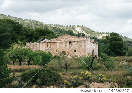Rustic abandoned farmhouse in scenic rural landscape with lush greenery and mountains Rustic abandoned farmhouse in scenic rural landscape with lush greenery and mountains 140892227