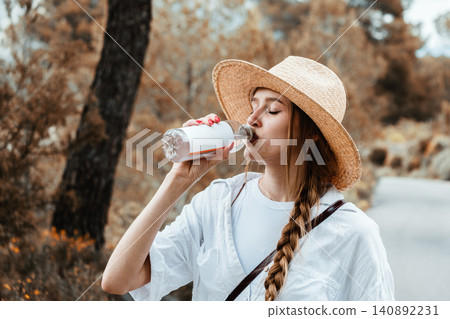 Woman enjoying refreshing drink on outdoor autumn adventure Woman enjoying refreshing drink on outdoor autumn adventure 140892231