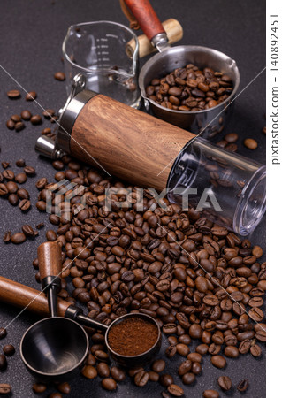 Roasted coffee beans, grinder and metal scoop on dark background Roasted coffee beans, grinder and metal scoop on dark background 140892451