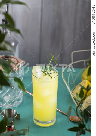 Pear Colins Cocktail. Highball glass filled with pear puree cocktail or mocktails surrounded by ingredients and bar tools on turquoise table surface Pear Colins Cocktail. Highball glass filled with pear puree cocktail or mocktails surrounded by ingredients and bar tools on turquoise table surface 140892545
