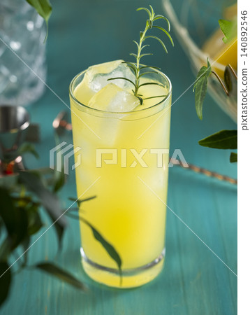 Pear Colins Cocktail. Highball glass filled with pear puree cocktail or mocktails surrounded by ingredients and bar tools on turquoise table surface 140892546