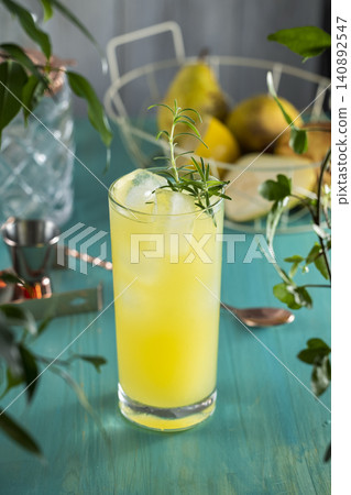 Pear Collins Cocktail. Highball glass filled with pear puree cocktail or mocktails surrounded by ingredients and bar tools on turquoise table 140892547