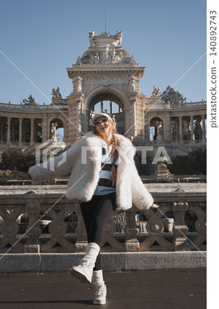 Fashionable woman posing in front of historic monument in stylish winter outfit 140892743