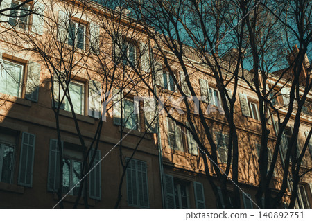 Charming european building with tree shadows and rustic architecture at sunset Charming european building with tree shadows and rustic architecture at sunset 140892751