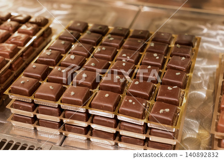 Gourmet artisan chocolate squares displayed in bakery showcase Gourmet artisan chocolate squares displayed in bakery showcase 140892832