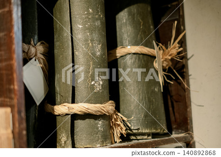 Old rustic bound volumes in wooden bookshelf with natural twine ties Old rustic bound volumes in wooden bookshelf with natural twine ties 140892868