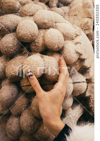 Hand touching stone texture with unique manicure and organic design elements Hand touching stone texture with unique manicure and organic design elements 140892888