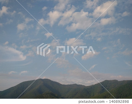 A landscape of clouds floating in the summer sky and lush green mountain ranges. A landscape of clouds floating in the summer sky and lush green mountain ranges. 140892898
