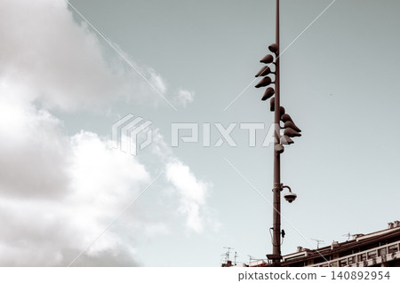 Pigeons perched on streetlight against overcast urban skyline Pigeons perched on streetlight against overcast urban skyline 140892954