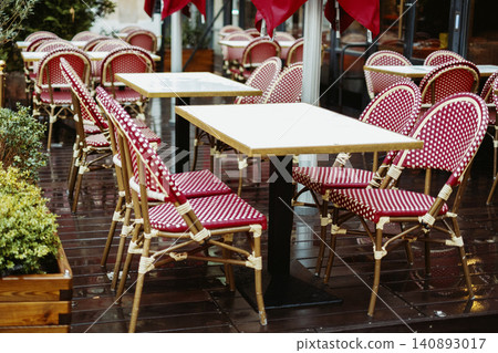 Outdoor cafe seating with red polka dot chairs on rainy day Outdoor cafe seating with red polka dot chairs on rainy day 140893017
