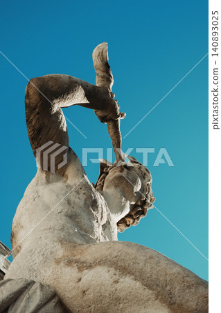 Majestic stone sculpture against vibrant blue sky with intricate details Majestic stone sculpture against vibrant blue sky with intricate details 140893025