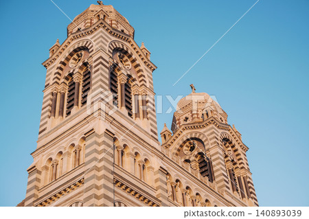 Majestic twin towers of marseille cathedral against clear blue sky at sunset Majestic twin towers of marseille cathedral against clear blue sky at sunset 140893039